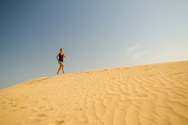 Genç kadın kum çöl dunes üzerinde çalışan