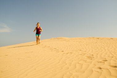 Genç kadın kum çöl dunes üzerinde çalışan