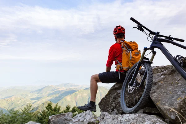 Mountainbiker kijken naar zicht op fietsweg in herfst bergen — Stockfoto