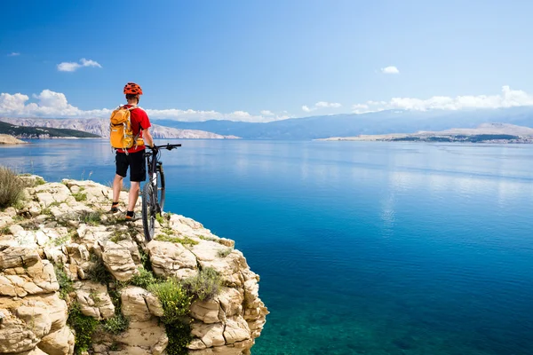 Mountain biking rider looking at inspiring sea and mountains