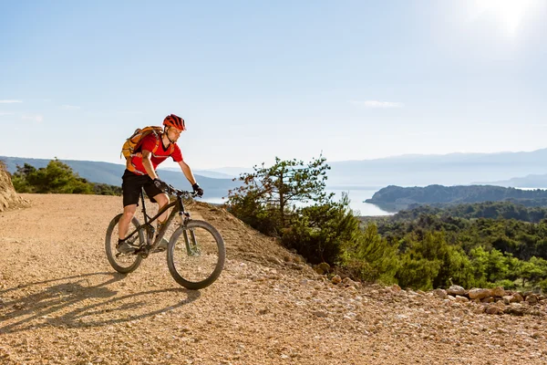 Montanha motociclista andando de bicicleta no mar — Fotografia de Stock