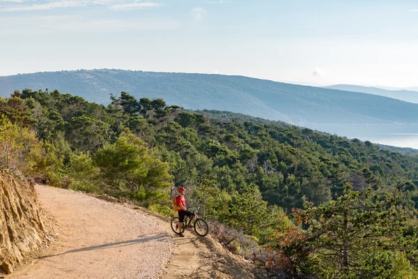 Mountainbiker rijden op de fiets bij de zee — Stockfoto