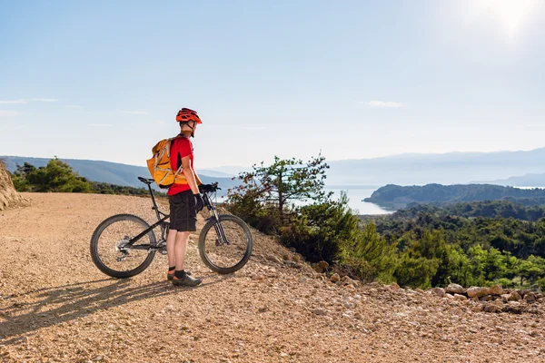 Mountain biker ogląda z widokiem na morze — Zdjęcie stockowe