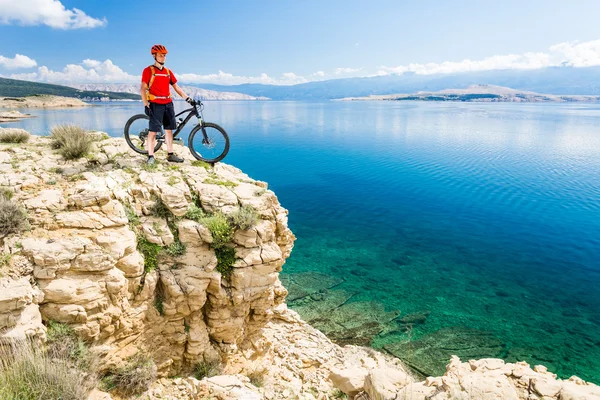 Mountain biker looking at view and riding on bike — Stock Photo, Image