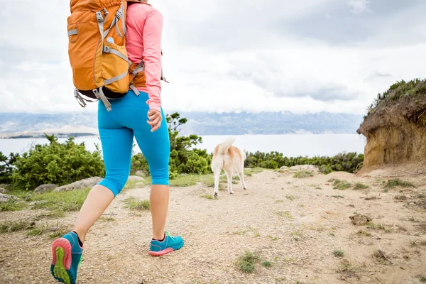 Frau wandert mit Hund auf Strandweg — Stockfoto