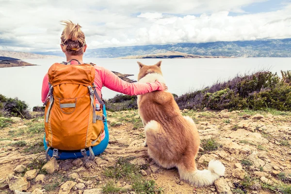 Wanderin mit Hund schaut aufs Meer — Stockfoto