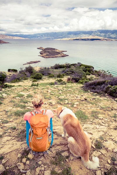 犬と海辺の歩道の上を歩いてハイキング女性 — ストック写真