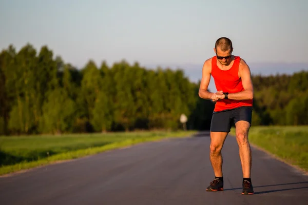 Uomo che corre su strada di campagna e formazione — Foto Stock