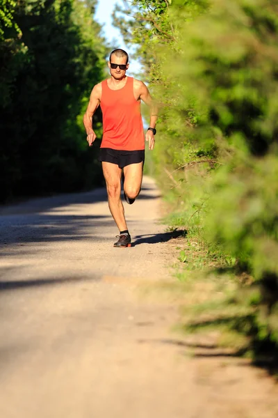 Hombre corriendo por la carretera del campo y la formación — Foto de Stock