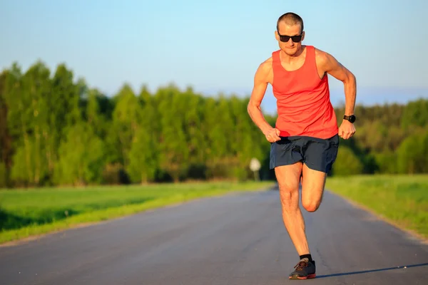 Чоловік біжить по сільській дорозі, тренує натхнення та мотивацію — стокове фото