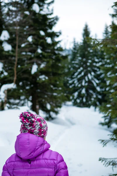 Mujer caminando en el bosque de invierno en sendero nevado —  Fotos de Stock