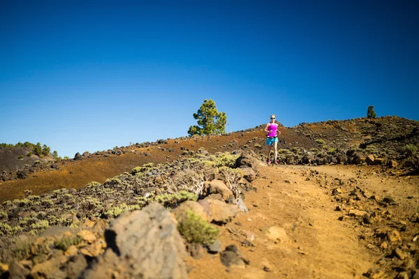 Young woman running in mountains on sunny summer day — Stock Photo, Image