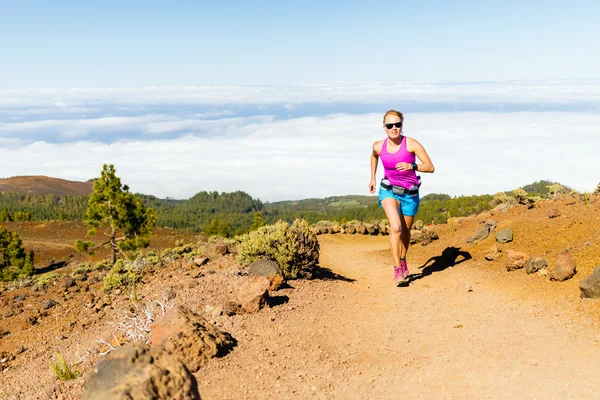 Mujer joven corriendo en las montañas en el soleado día de verano —  Fotos de Stock
