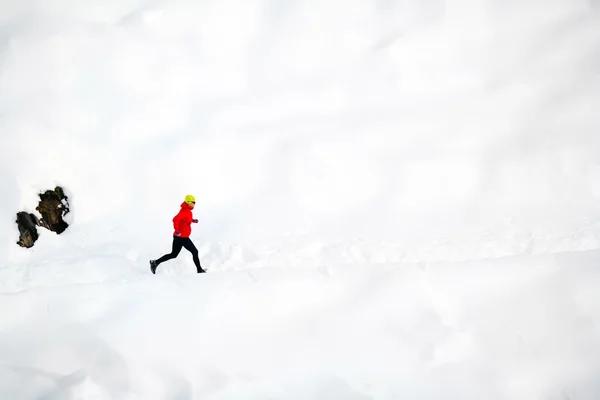 Женщина бежит по снегу в горах — стоковое фото