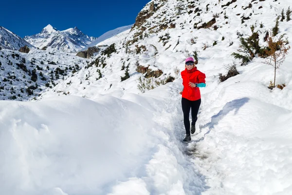 Жінка біжить в зимових горах — стокове фото
