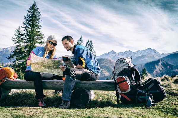 Couple hikers with map in mountains