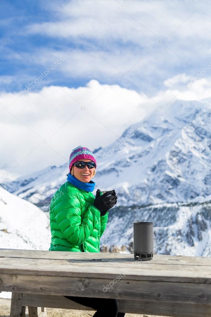 Woman drinking in winter mountain base camp