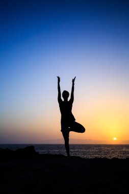 Kadın egzersiz yoga gün batımı siluet