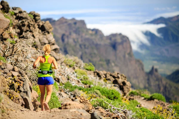 Junge Frau läuft oder wandert in den Bergen — Stockfoto