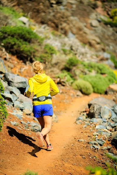 Mujer joven corriendo en las montañas — Foto de Stock