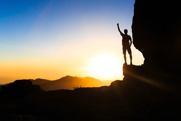 Uomo trekking arrampicata silhouette successo in montagna tramonto — Foto Stock