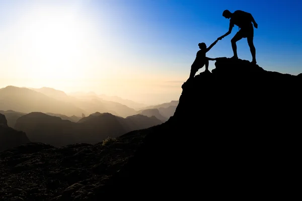 Teamwerk paar wandelen helpende hand — Stockfoto