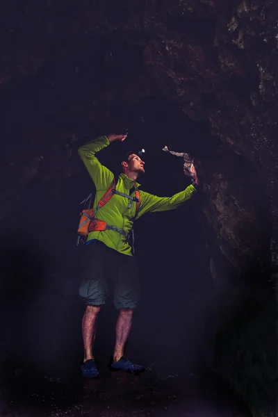 Hombre explorando cueva oscura subterránea — Foto de Stock