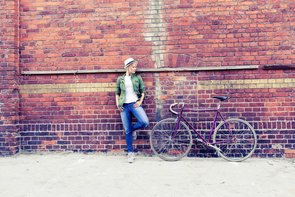 Young woman with vintage road bike in city