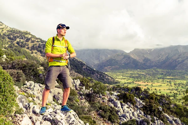 Escursionismo uomo controllo direzione in montagna — Foto Stock