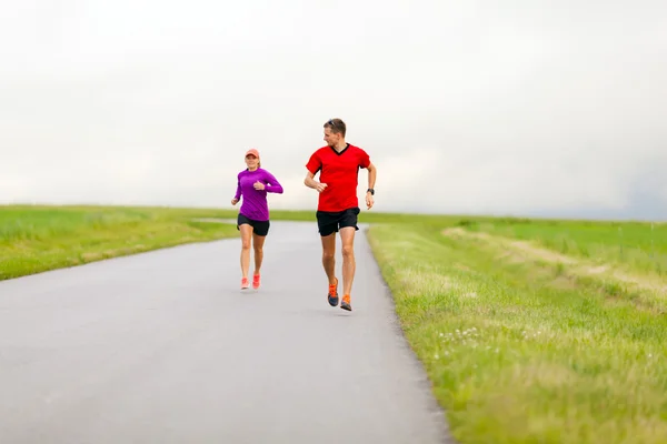 Pareja corriendo por el camino del campo — Foto de Stock