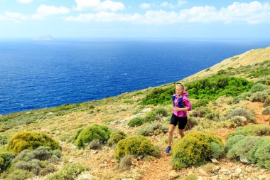 Happy woman cross country running in beautiful mountains