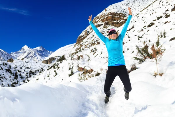 Woman jumping and running in winter mountains — Stockfoto