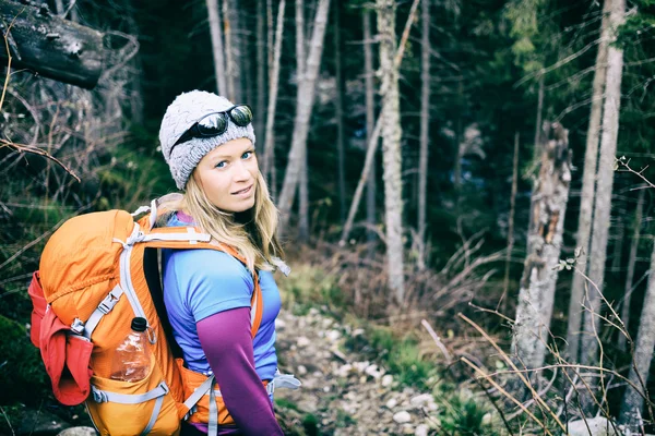 Woman hiking in winter cold dark winter forest — Stok fotoğraf