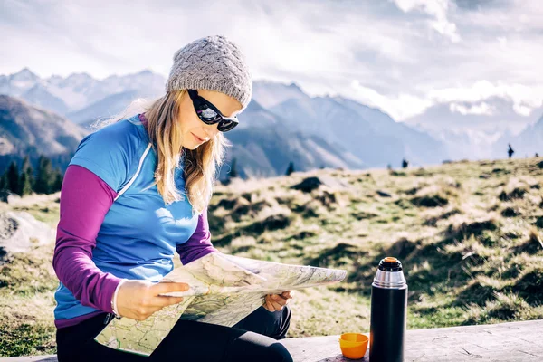 Woman checking map hiking in mountains — Stok fotoğraf