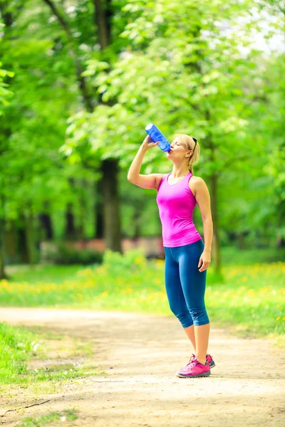 Kvinnan löpare dricksvatten på utbildning — Stockfoto