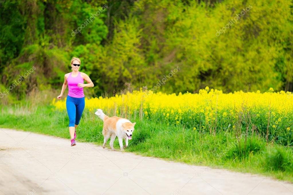 Woman running in summer park with dog