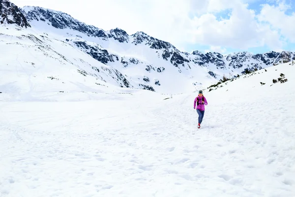 冬の晴れた日に山で走っている幸せな女性 — ストック写真