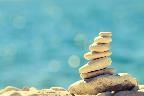 Piedras equilibrio en la playa, pila sobre el mar azul — Foto de Stock