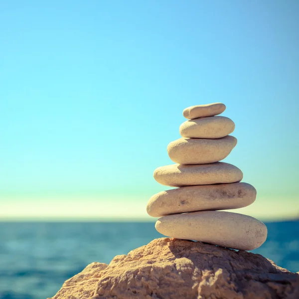 Steine balancieren am Strand, stapeln sich über blauem Meer — Stockfoto