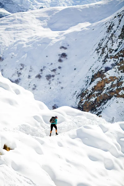 Woman hiking in white winter mountains — Stok fotoğraf