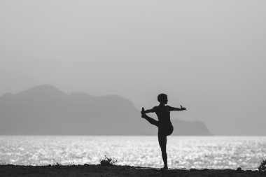 Woman meditating in yoga pose silhouette