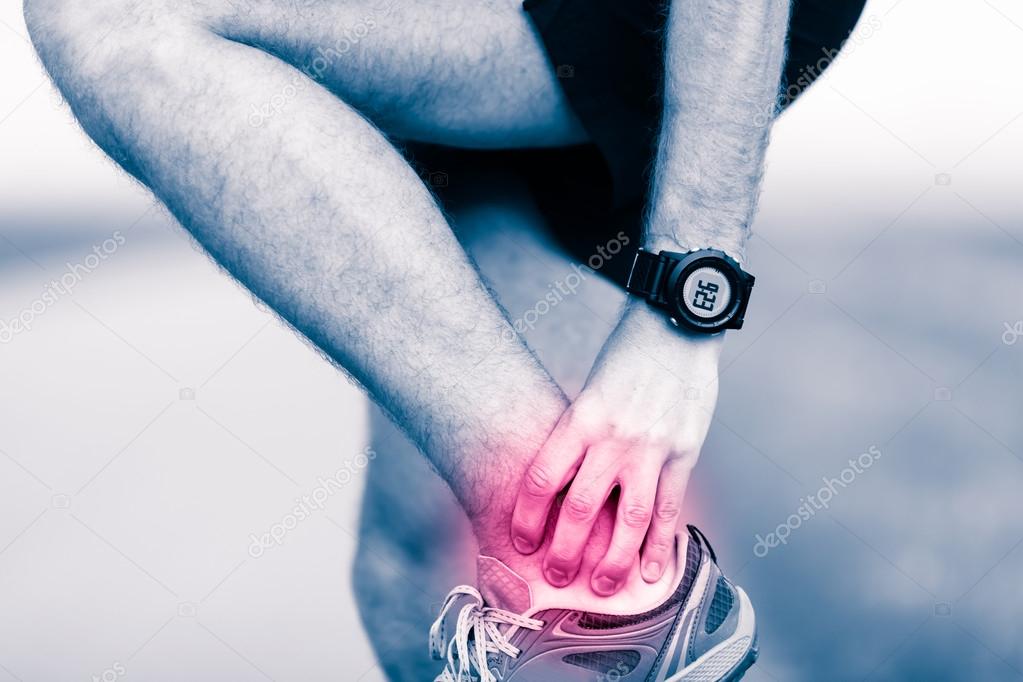 Leg ankle pain, man holding sore and painful foot