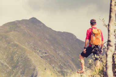 Hiking man with backpack in mountains