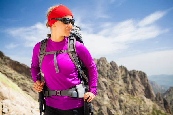 Caminhadas de mulher com mochila em montanhas inspiradoras — Fotografia de Stock
