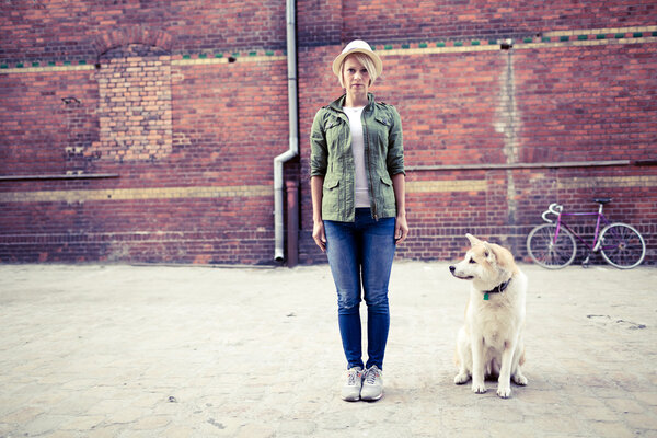 Hipster woman with dog and vintage road bike in city