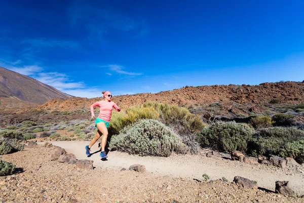 Mujer joven corriendo en las montañas en el soleado día de verano — Foto de Stock