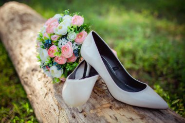 Bir buket ile kadın beyaz düğün ayakkabıları