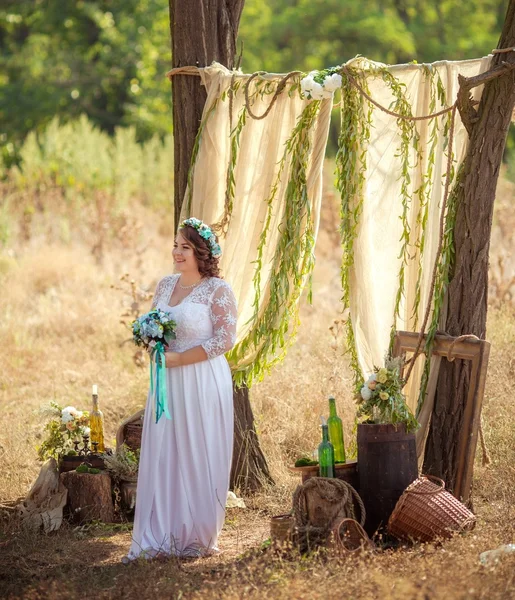 Невеста с букетом в саду — стоковое фото
