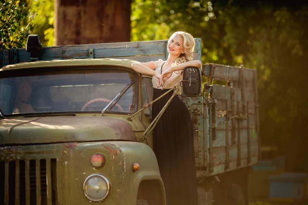 Mooie vrouw poseren in de buurt van oude vrachtwagen — Stockfoto