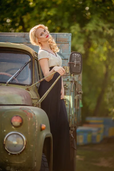 Beautiful woman posing near old truck — Stock Photo, Image